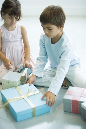 Children reaching for Christmas presents Stock Photo - Premium Royalty-Free, Code: 632-01380611