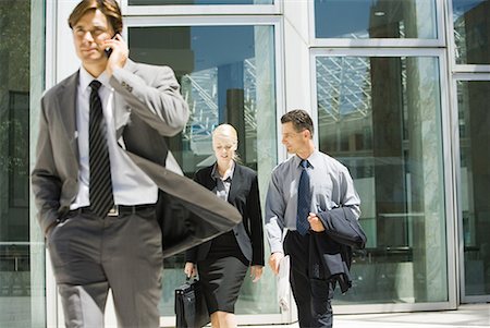 simsearch:632-05401320,k - Male and female business colleagues talking as they leave office building, man using cell phone in foreground Stock Photo - Premium Royalty-Free, Code: 632-01612876