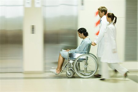 disabled patient doctor picture - Hospital staff pushing man in wheelchair, blurred motion Stock Photo - Premium Royalty-Free, Code: 632-01613005