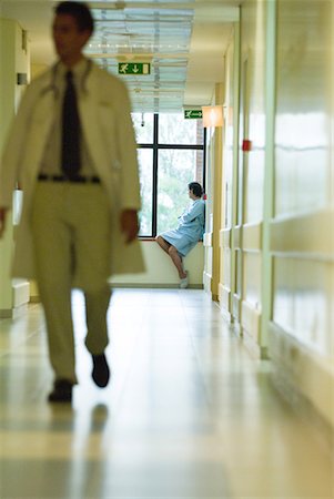 simsearch:632-01613036,k - Man sitting, looking out window, wearing hospital gown, doctor walking in foreground Stock Photo - Premium Royalty-Free, Code: 632-01613008