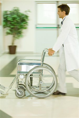 simsearch:632-01613036,k - Male doctor pushing empty wheelchair, blurred motion Stock Photo - Premium Royalty-Free, Code: 632-01613021