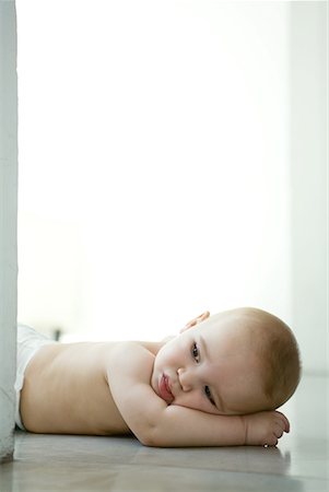 Baby lying on floor with head resting on arm Stock Photo - Premium Royalty-Free, Code: 632-01636917
