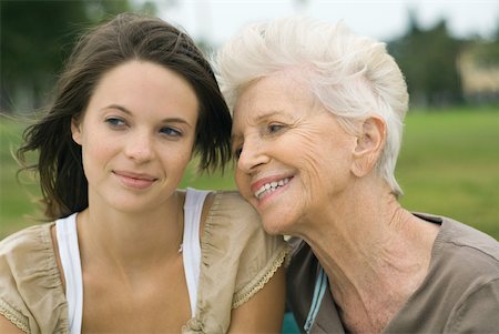 Senior woman leaning head on teenage granddaughter's shoulder, both smiling and looking away Stock Photo - Premium Royalty-Free, Code: 632-01785127