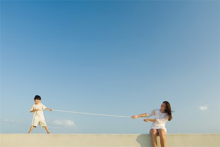 simsearch:632-05604001,k - Little boy and woman playing tug of war, blue sky in background Stock Photo - Premium Royalty-Free, Code: 632-01785396