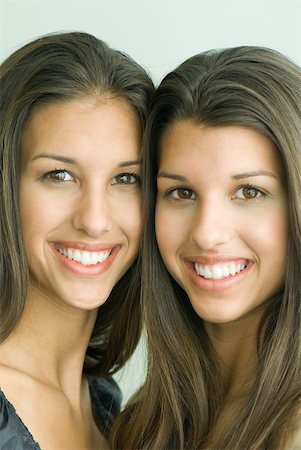 Two twin teenage sisters smiling at camera, cheek to cheek, portrait Foto de stock - Sin royalties Premium, Código: 632-01827751