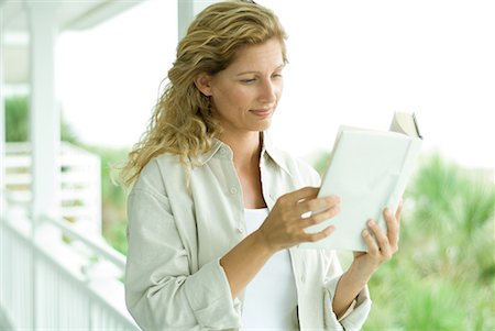 simsearch:632-03083700,k - Woman standing on porch, reading book, close-up Stock Photo - Premium Royalty-Free, Code: 632-02038848