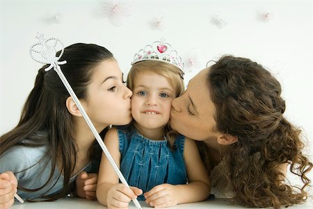 Girl dressed as princess, holding wand, mother and sister kissing her cheeks Foto de stock - Sin royalties Premium, Código: 632-02128417