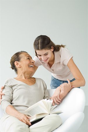 simsearch:400-05697219,k - Grandmother holding book, granddaughter looking over her shoulder Stock Photo - Premium Royalty-Free, Code: 632-02227928