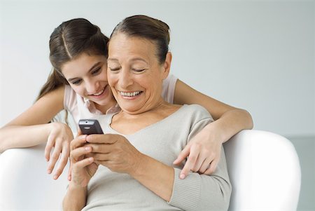 simsearch:400-05697219,k - Grandmother holding cell phone, granddaughter looking over her shoulder Stock Photo - Premium Royalty-Free, Code: 632-02227942