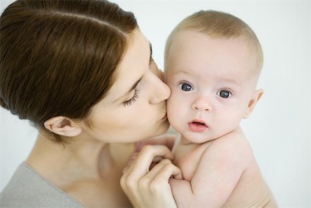 simsearch:632-03027302,k - Mother kissing infant on the cheek, baby looking at camera Stock Photo - Premium Royalty-Free, Code: 632-02282495