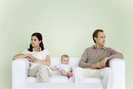 simsearch:632-01148228,k - Couple sitting on couch with baby between them, both looking away Stock Photo - Premium Royalty-Free, Code: 632-02282498