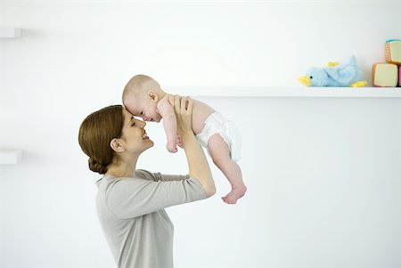 simsearch:632-03027302,k - Mother lifting baby in the air, touching foreheads, side view Stock Photo - Premium Royalty-Free, Code: 632-02282505