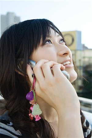relieved person happy - Young woman talking on cell phone, looking up, close-up Stock Photo - Premium Royalty-Free, Code: 632-02344449