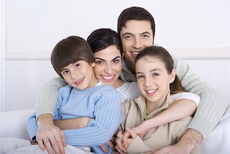 simsearch:695-05769087,k - Father embracing his wife and two children, all smiling at camera Stock Photo - Premium Royalty-Free, Code: 632-02345163