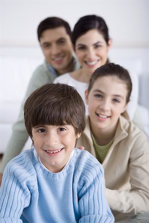 simsearch:695-05769087,k - Young boy sitting with his family behind him, smiling, portrait Stock Photo - Premium Royalty-Free, Code: 632-02345195