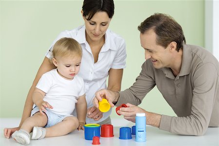 simsearch:632-03027302,k - Father showing toddler plastic toys, mother watching Stock Photo - Premium Royalty-Free, Code: 632-02416249