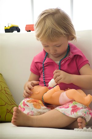 Little girl feeding baby doll with bottle Stock Photo - Premium Royalty-Free, Code: 632-02645143