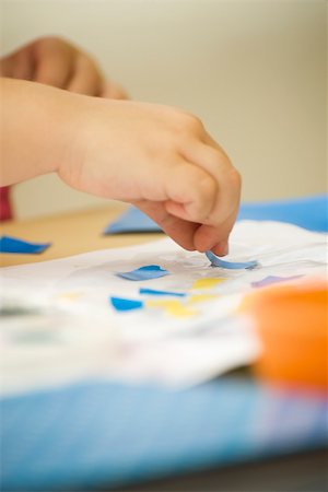 Child making collage with glue and paper, cropped view of hands Stock Photo - Premium Royalty-Free, Code: 632-02645191