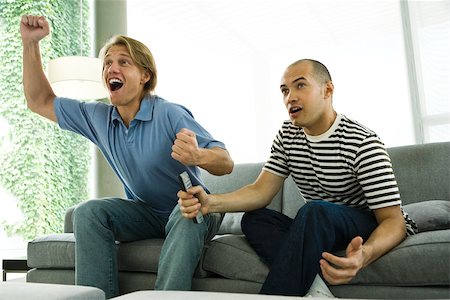 simsearch:628-05817772,k - Two men watching TV and cheering on sofa Stock Photo - Premium Royalty-Free, Code: 632-02744851