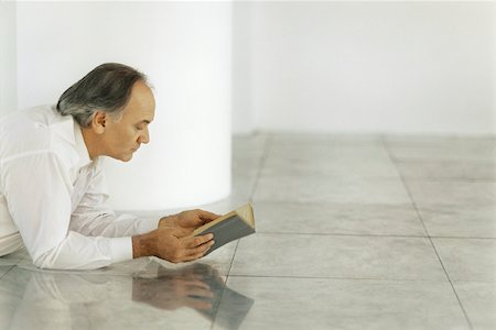 reader - Senior man lying on tiled floor reading book Stock Photo - Premium Royalty-Free, Code: 632-02745127