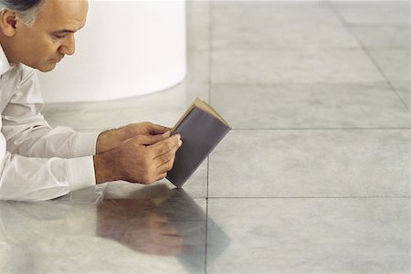 reader - Senior man lying on tiled floor reading book Stock Photo - Premium Royalty-Free, Code: 632-02745137