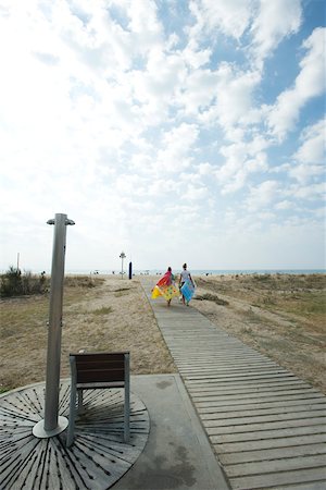 people walking in the distance - Teen girls walking on boardwalk at beach Stock Photo - Premium Royalty-Free, Code: 632-02745235