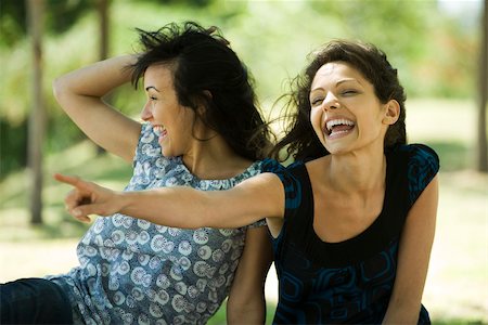 Two young women laughing outdoors, one pointing Stock Photo - Premium Royalty-Free, Code: 632-02885177