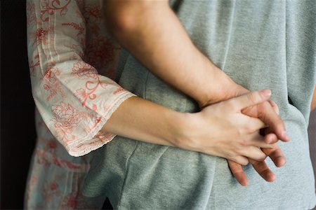 Couple embracing, holding hands, cropped Stock Photo - Premium Royalty-Free, Code: 632-02885459