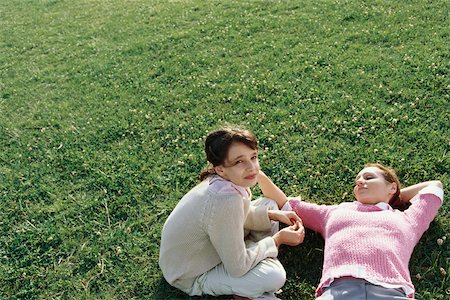 simsearch:632-03424324,k - Mother and daughter relaxing on grass together, girl looking at camera Stock Photo - Premium Royalty-Free, Code: 632-03026992