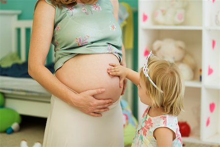 Little girl touching mother's pregnant belly Stock Photo - Premium Royalty-Free, Code: 632-03027250