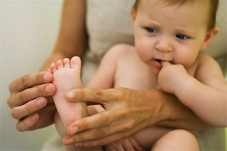 feet scale woman - Mother holding baby on lap, playing with baby's foot, cropped Stock Photo - Premium Royalty-Free, Code: 632-03027298