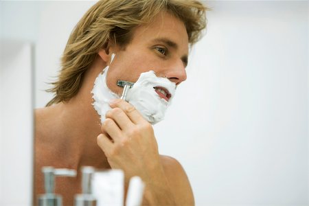 shaving (hygiene, male) - Man shaving with razor looking at self in mirror Stock Photo - Premium Royalty-Free, Code: 632-03027414