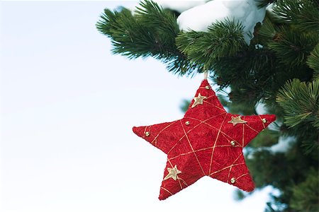 Star Christmas ornament hanging from snow-covered branch Stock Photo - Premium Royalty-Free, Code: 632-03027574