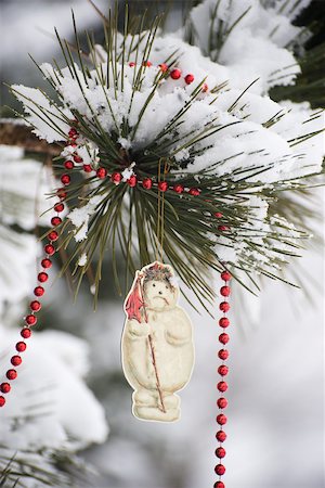 simsearch:632-06118429,k - Snowman Christmas ornament and beaded garland hanging from snow-covered tree branch Stock Photo - Premium Royalty-Free, Code: 632-03027595