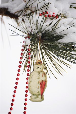 simsearch:632-06354416,k - Snowman Christmas ornament and beaded garland hanging from snow-covered tree branch Stock Photo - Premium Royalty-Free, Code: 632-03027613