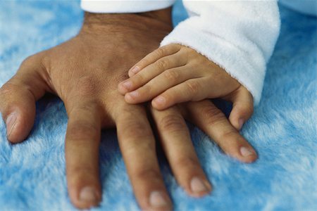 Child's hand placed on adult's hand Foto de stock - Sin royalties Premium, Código: 632-03082920