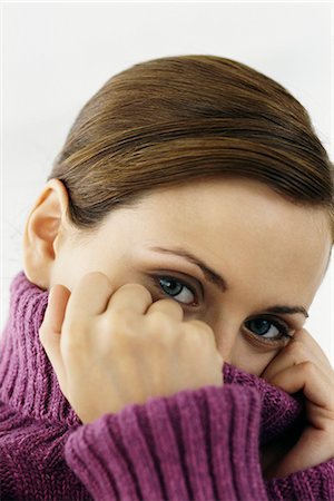 Woman pulling turtleneck collar over mouth and nose, portrait Stock Photo - Premium Royalty-Free, Code: 632-03082951