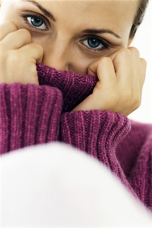 Woman pulling turtleneck collar over mouth and nose, portrait Stock Photo - Premium Royalty-Free, Code: 632-03082952