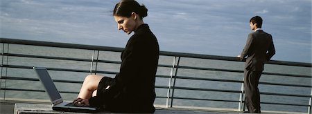 simsearch:632-03083042,k - Businesswomen on waterfront bench using laptop computer, man at nearby railing looking at view Stock Photo - Premium Royalty-Free, Code: 632-03083046