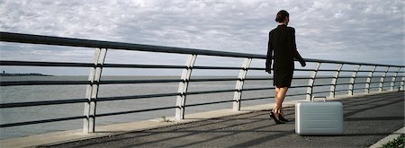 simsearch:632-03083042,k - Briefcase set on ground near waterfront railing, businesswoman walking away Stock Photo - Premium Royalty-Free, Code: 632-03083042