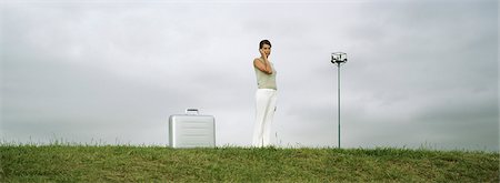simsearch:632-03083042,k - Woman standing in field using cell phone, briefcase on ground nearby Stock Photo - Premium Royalty-Free, Code: 632-03083074