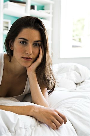 Woman lying on bed leaning on elbow looking at camera Stock Photo - Premium Royalty-Free, Code: 632-03083161