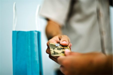 Man paying for purchase with credit card, cropped, close-up Stock Photo - Premium Royalty-Free, Code: 632-03083371