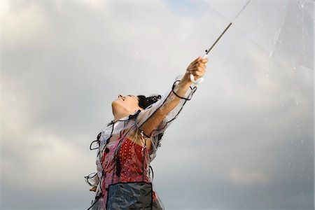 Jeune femme debout à l'extérieur sur une journée pluvieuse, laissant la pluie tomber sur son visage Photographie de stock - Premium Libres de Droits, Code: 632-03083418