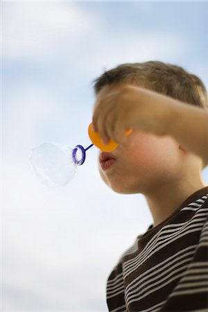 simsearch:632-05604245,k - Little boy blowing bubble with bubble wand, low angle view Stock Photo - Premium Royalty-Free, Code: 632-03083453