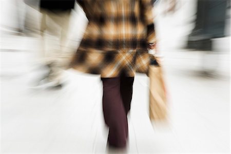 panning (camera technique) - Shopper walking with shopping bag in hand, rear view, cropped Stock Photo - Premium Royalty-Free, Code: 632-03083515