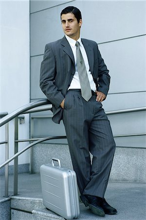 simsearch:632-03083042,k - Businessman leaning against railing, briefcase on sidewalk at feet Stock Photo - Premium Royalty-Free, Code: 632-03083714