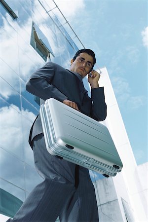 simsearch:632-03083042,k - Businessman carrying briefcase using cell phone outside office building Stock Photo - Premium Royalty-Free, Code: 632-03083715