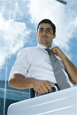 simsearch:632-03083042,k - Businessman standing outside office building carrying briefcase, adjusting tie Stock Photo - Premium Royalty-Free, Code: 632-03083729