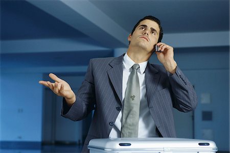 simsearch:632-03083042,k - Businessman talking on cell phone, making frustrated gesture with hand Stock Photo - Premium Royalty-Free, Code: 632-03083736